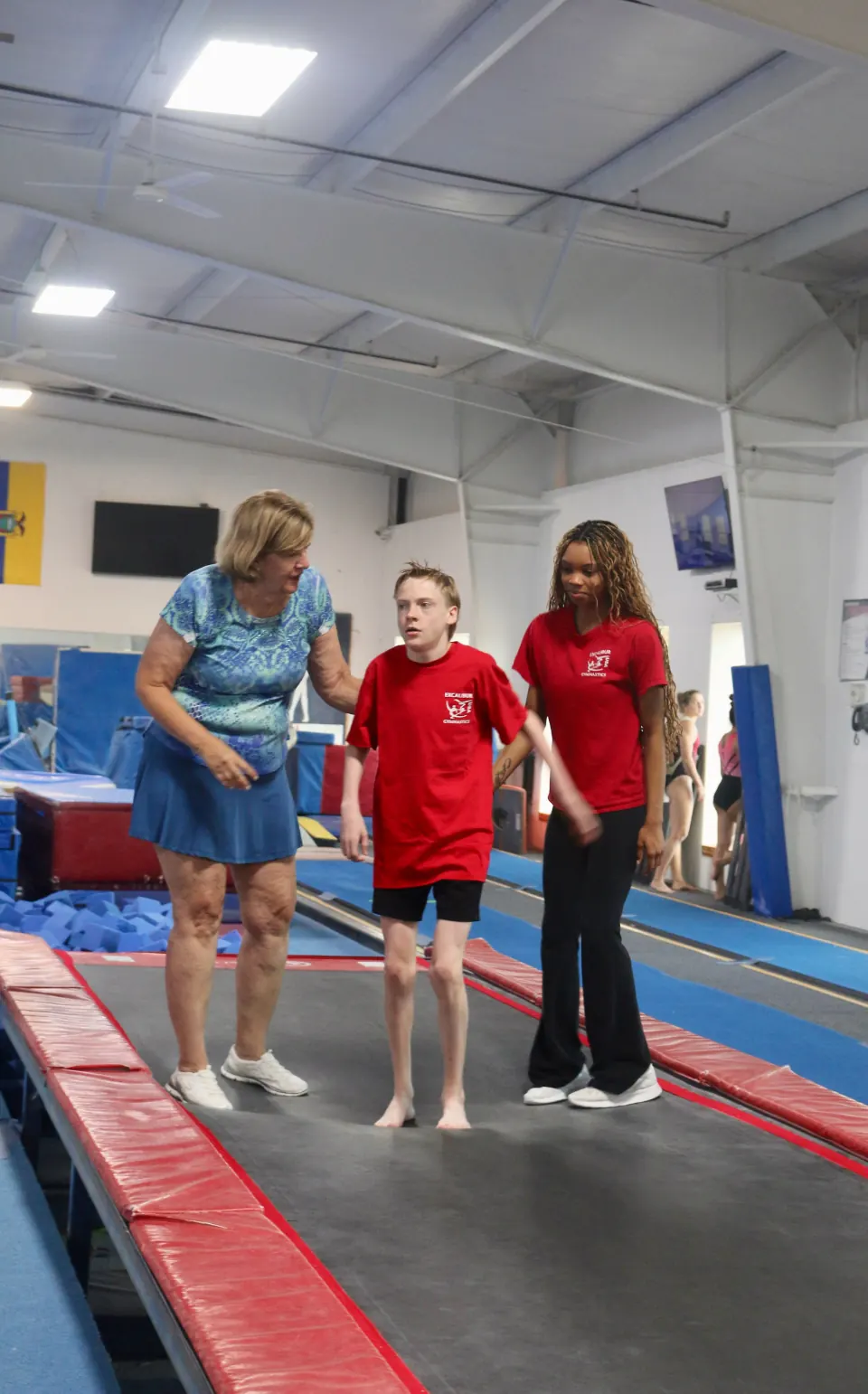 An athlete receiving support during adaptive gymnastics at Excalibur