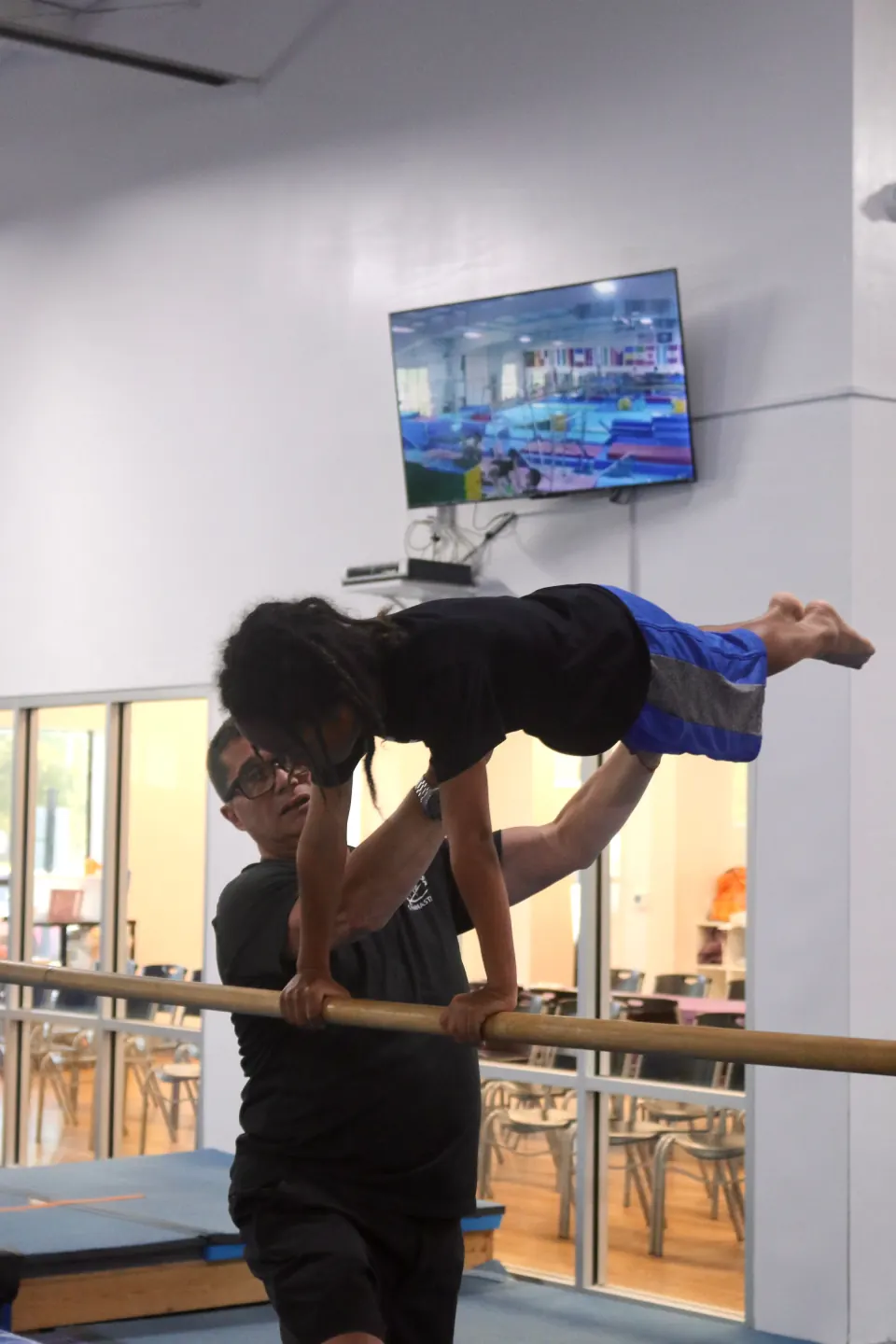 A gymnast practicing a boys program skill
